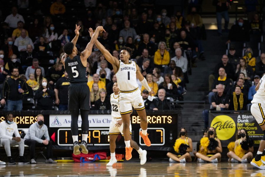 On Cincinattis side of the court, senior David DeJulius goes up for a three-pointer while Wichita States sophomore Tyson Etienne makes to block the shot.