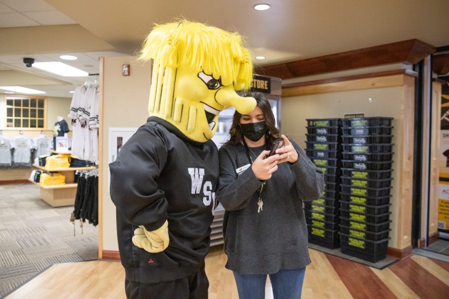 Student Engagement Intern for the Office of Admissions Kaylie Krichati-Aikins shows WuShock the selfie they took while filming content for the WSU Tik Tok page.