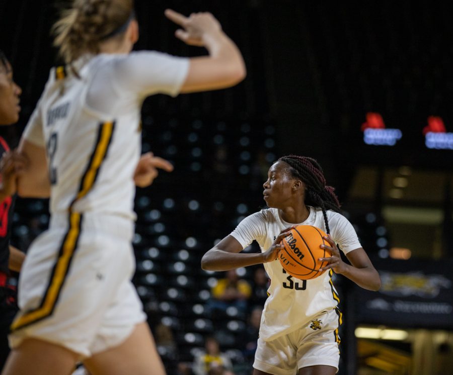 Junior Jane Asinde looks around to pass the ball during the game against Houston at Charles Koch Arena on Jan. 5.