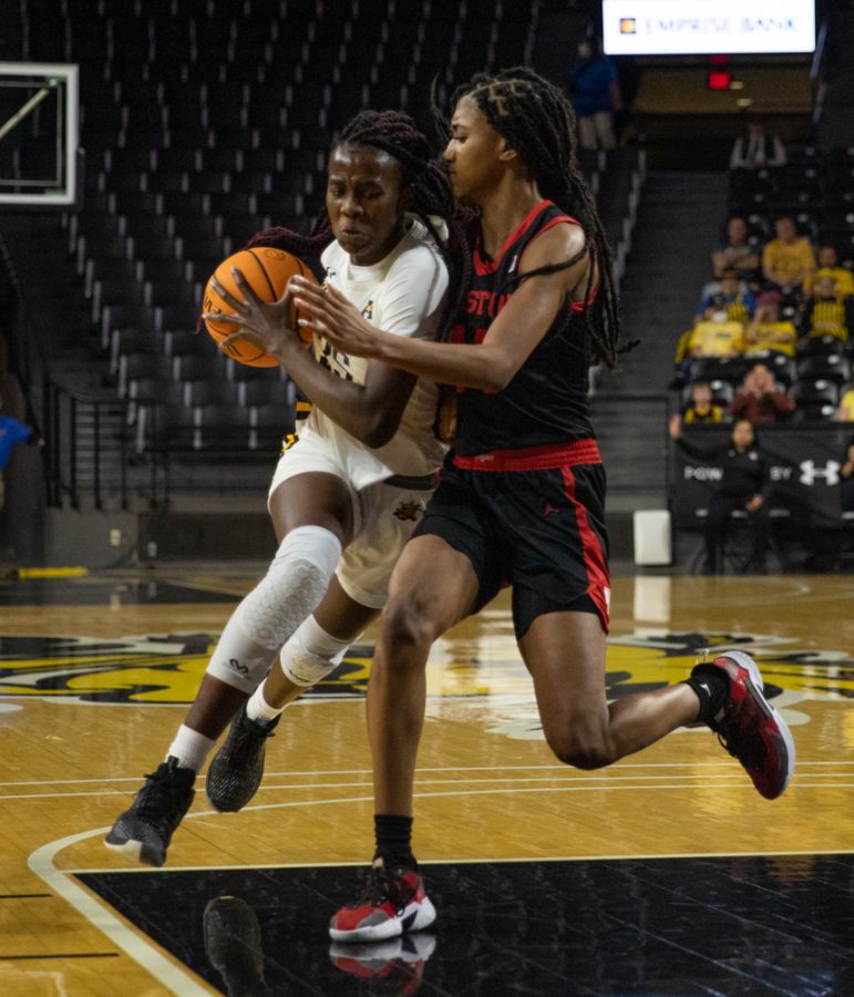 Junior Jane Asinde dribbles around a handsy Houston player during the game against Houston at Charles Koch Arena on Jan. 5.