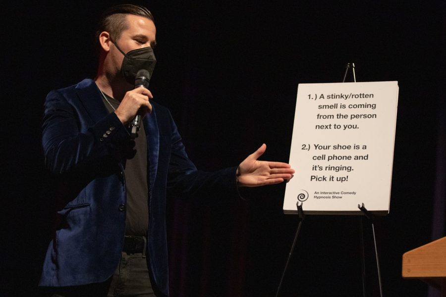 David Hall begins the Cards Against Hypnosis by asking the audience to vote between two answers. Hall invented the game in 2018 and has performed at Wichita State University twice.