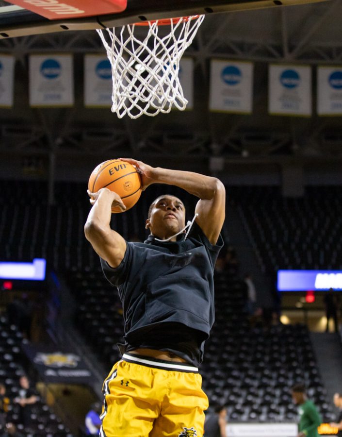 Junior Joe Pleasant goes up for a dunk while warming up for the game against Tulane on Jan. 12.