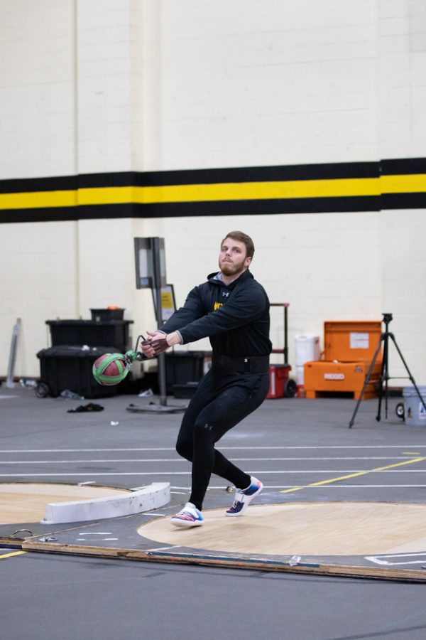 Senior Michael Bryan practices throwing weights during the track and field event on Feb. 4.