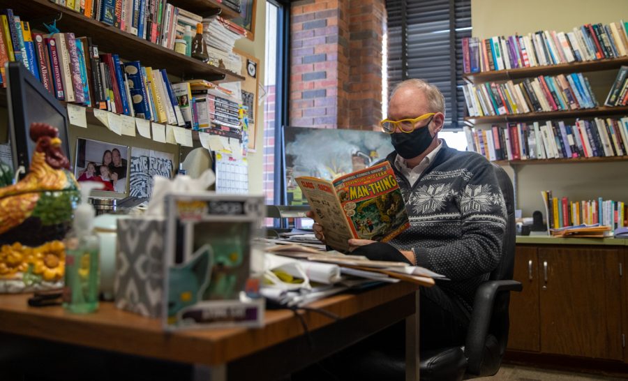 Darren Defrain, Associate Professor and Director of the Writing Program, reads comic in his office during his down time on Feb, 1.