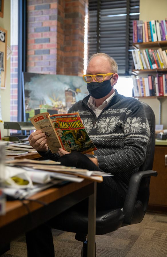 Darren Defrain, Associate Professor and Director of the Writing Program, reads comic in his office during his down time on Feb, 1.