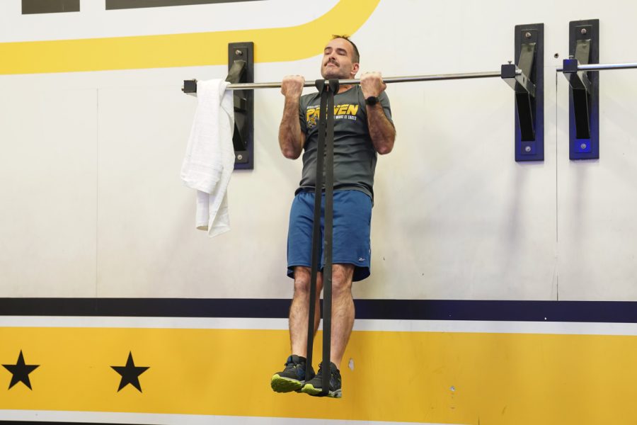 A man does front pull ups at F45 on March 22nd at Heskett Center.