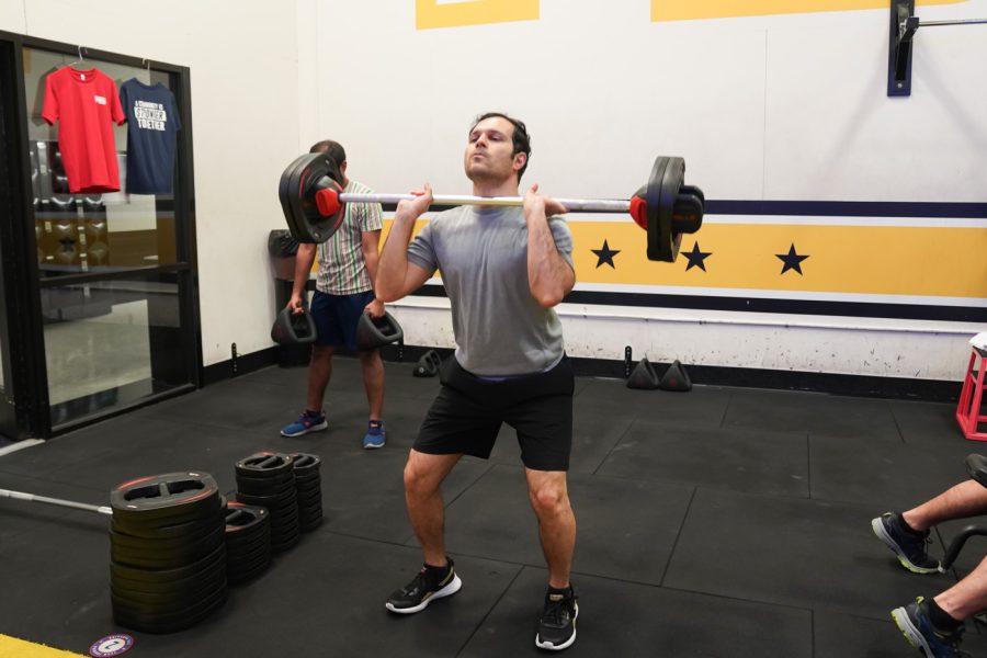 Ali does squats with weight on shoulder at F45 on March 22nd at Heskett Center.