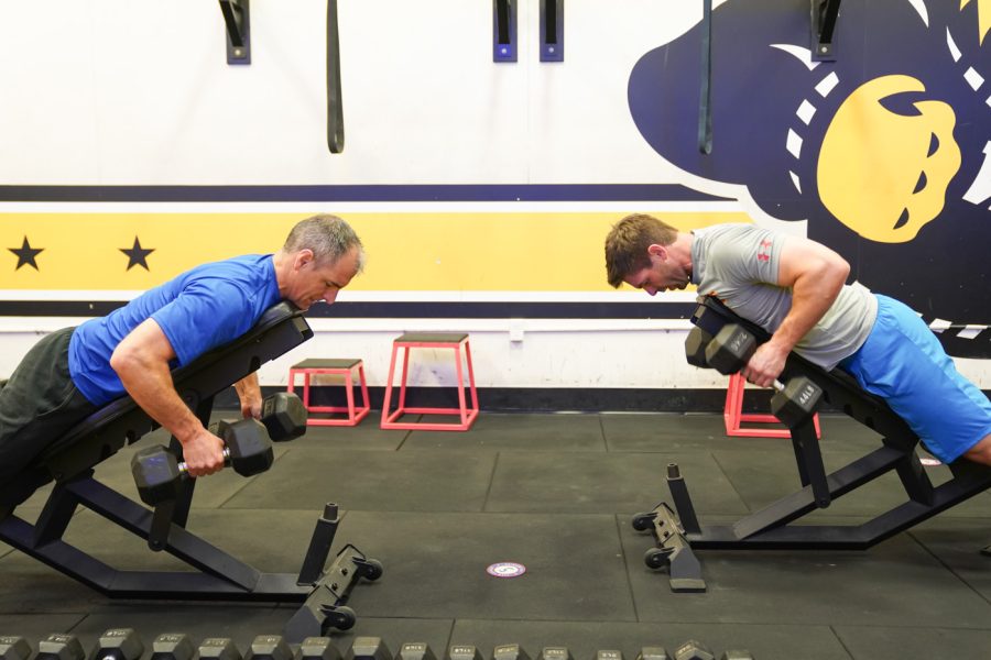Scott Schul and Clint Carrier do a lats exercise at F45 on March 22nd at Heskett Center.