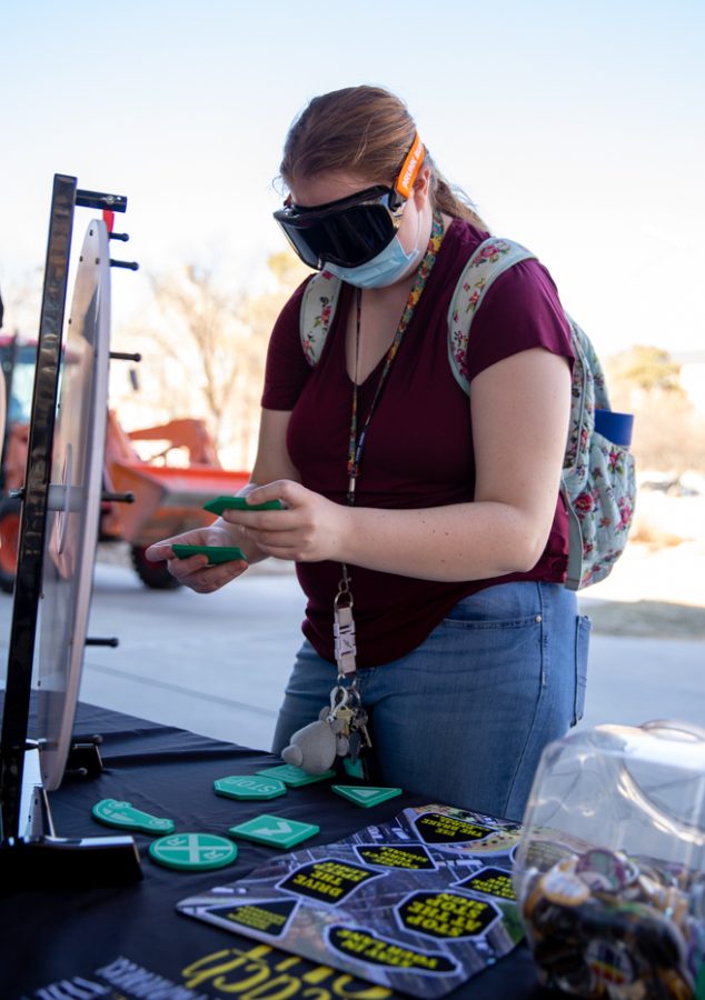 Wichita State student tries to fit all of the foam road signs in the correct spots while wearing drunk goggles during the Student health CAPPS Tipsy Turvy booth on March 1.