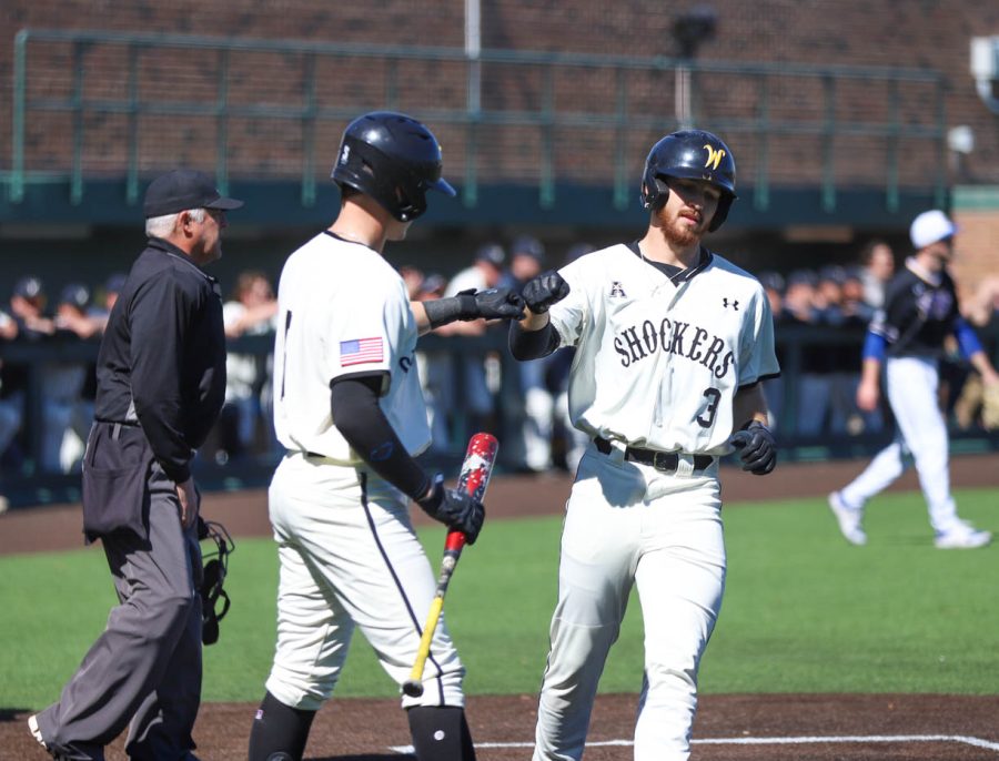 Sawyre Thornhill celebrates with Xavier Casserilla after scoring a run during WSU's game against South Dakota State on March 13 inside Eck Stadium.