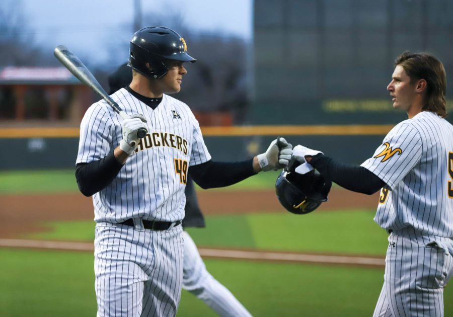 Payton Tolle fist-bumps Chuck Ingram during WSUs game against Kansas on March 23 inside Eck Stadium.