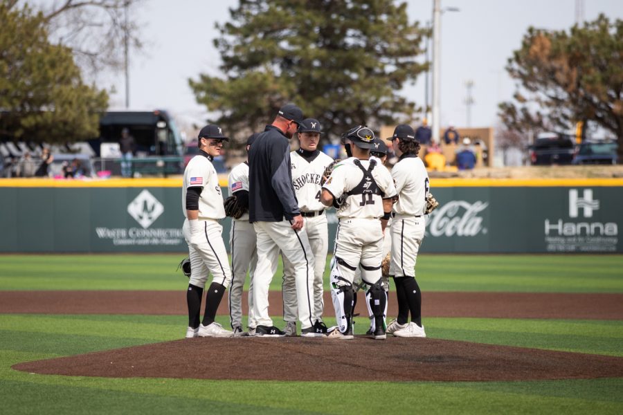 The Shockers baseball team meets at the pitchers mound in between innings.