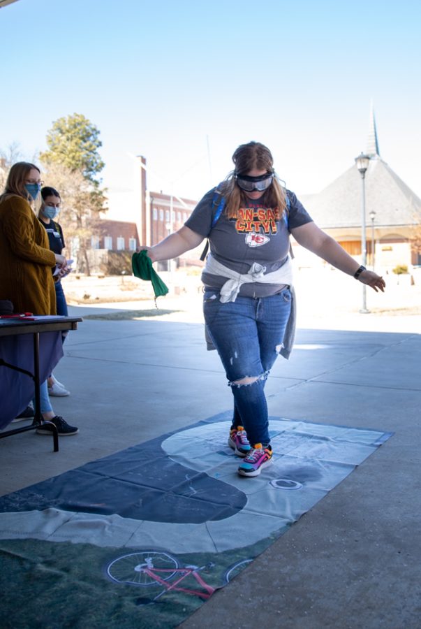 Sophomore criminal justice major Kaitlyn Ainsworth tries to navigate the winding sidewalk mat at the Student health CAPPS Tipsy Turvy booth on March 1.