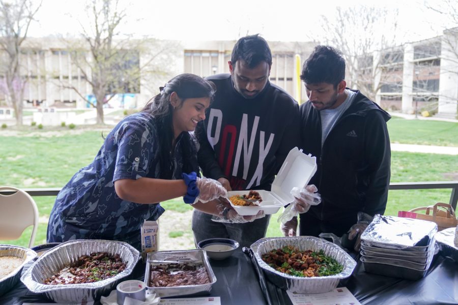 Students, who served Indian food, make to-go boxes at Interfest, an event organized by the International Student Union on April 13 by the Neff Hall Courtyard.