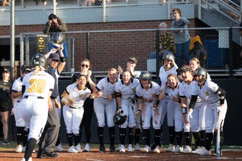 After scoring a home run for the Shockers, junior Addison Barnard runs to home plate to meet the WSU softball team during the game against KU.