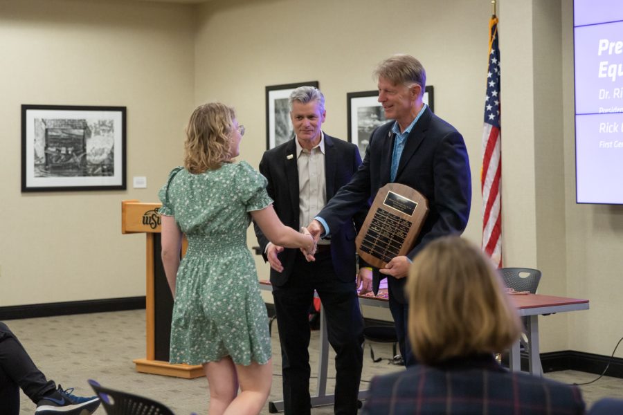 Spectrum officer Allison Campbell receives the Richard D. Muma and Rick A. Case Equality Scholarship from President Rick Muma and First Gentleman Rick Case during the Lavender Graduation. The scholarship was created to support LGBTQ students at WSU, and three received it on April 28, 2022.