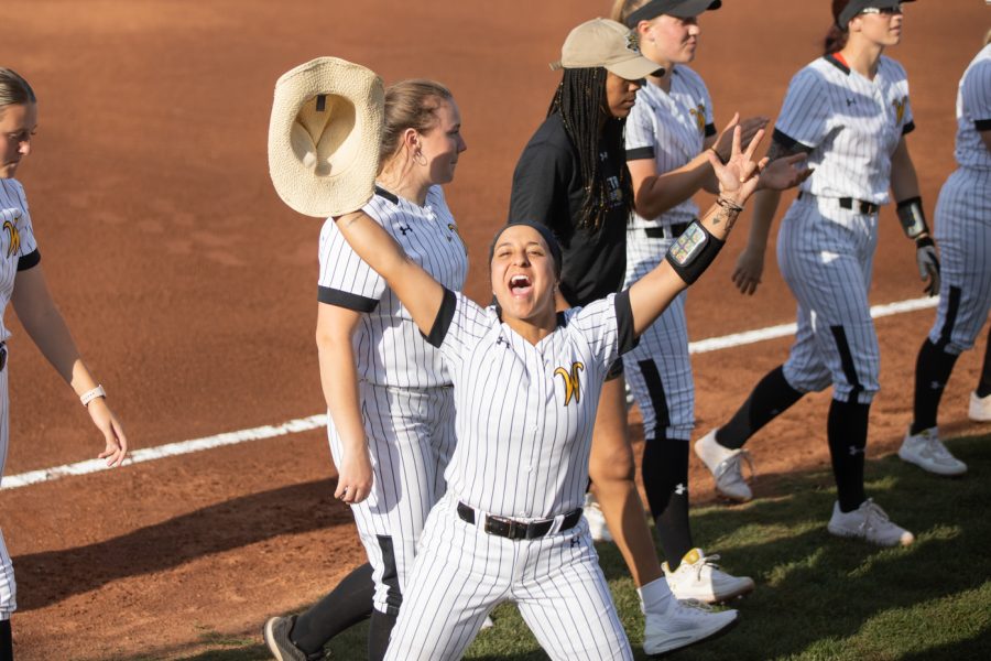 Sophomore Madyson Espinosa cheers for Wichita State before the game against KU begins on April 20. WSU defeated KU, 9-1.