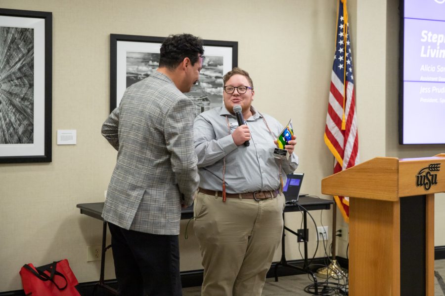 Coordinator of Student Diversity Programs Armando Minjarez receives the Stephanie Mott Living Authentically Award from Spectrum officer Jess Prudence. The award was given to an individual who supported, educated and created LGBTQ+ safe environments around campus.