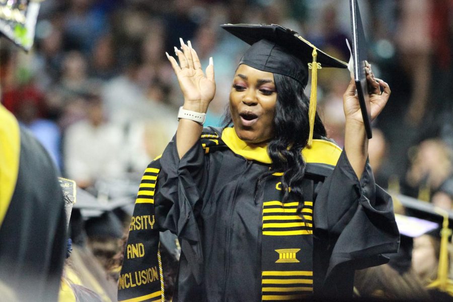 A graduate celebrates with her classmates after receiving the diploma.