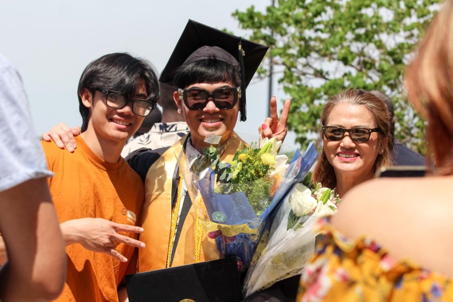 Spring 2022 graduate poses with their family after the Spring Commencement Ceremony on May 14 in front of Charles Koch Arena.
