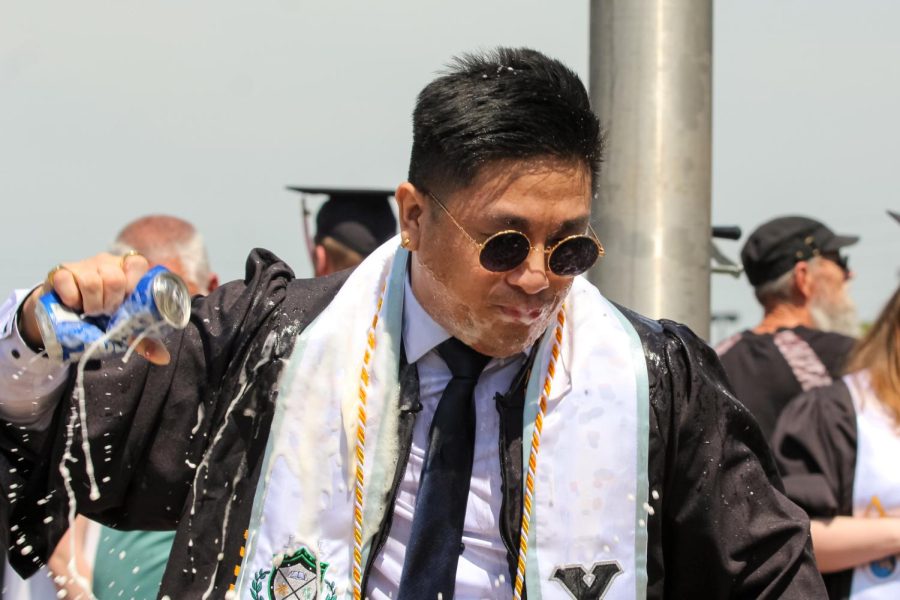 Spring 2022 graduate celebrates by drinking Bud Light after the Spring Commencement Ceremony on May 14.