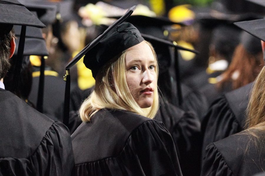 Graduate observes the crowd at Charles Koch Arena for the Spring Commencement Ceremony on May 14, 2022.