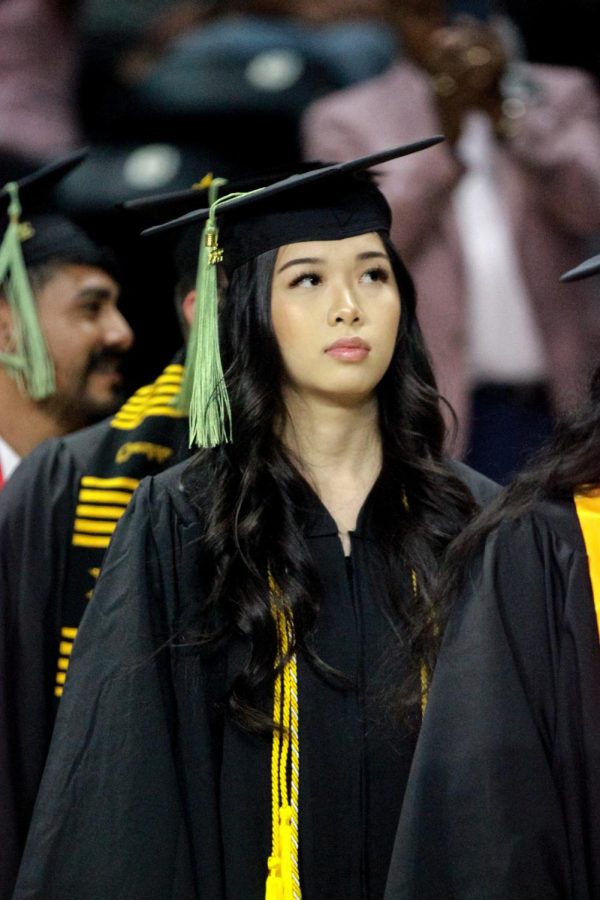 Tammy Pham lines up to take a photo and recieve her diploma at the Spring Commencement Ceremony.