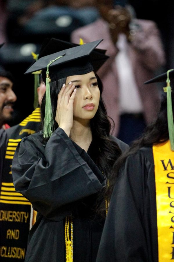 Tammy Pham lines up to take a photo and recieve her diploma at the Spring Commencement Ceremony.