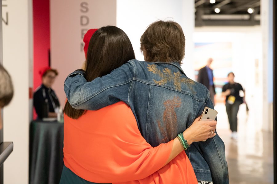Two individuals at the Summer 2022 Exhibition Opening Celebration hug. Two exhibitions opened: Reemergence and Reconnecting: A Youth Arts Council Takeover and Deep Dive: Selections from the Permanent Collection.