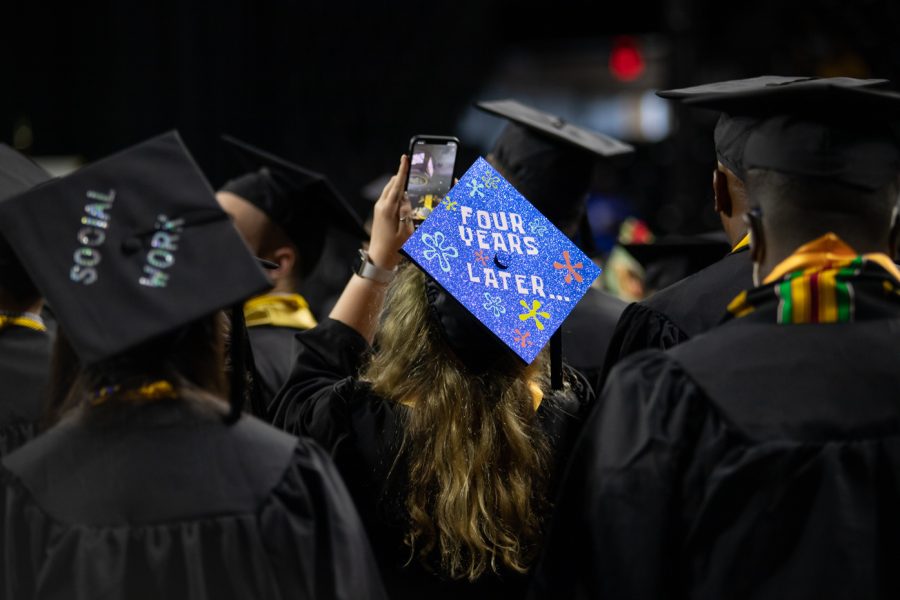 With a Spongebob-themed cap, a graduate student takes a video of Koch Arena before the ceremony begins.