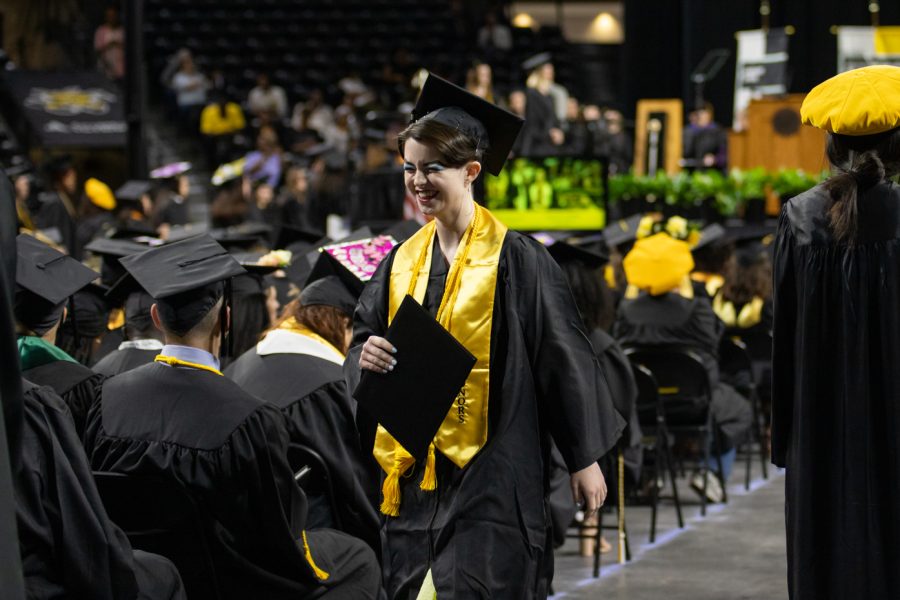 After receiving their diploma, a graduate laughs and walks back to their seat.