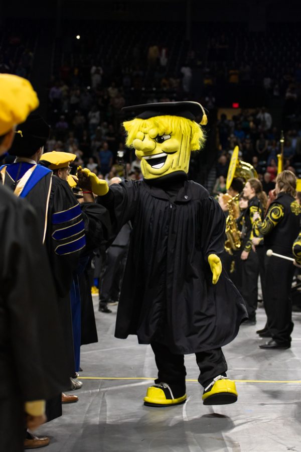 WuShock high fives graduate at the end of the first 2022 Spring Commencement Ceremony on May 14.