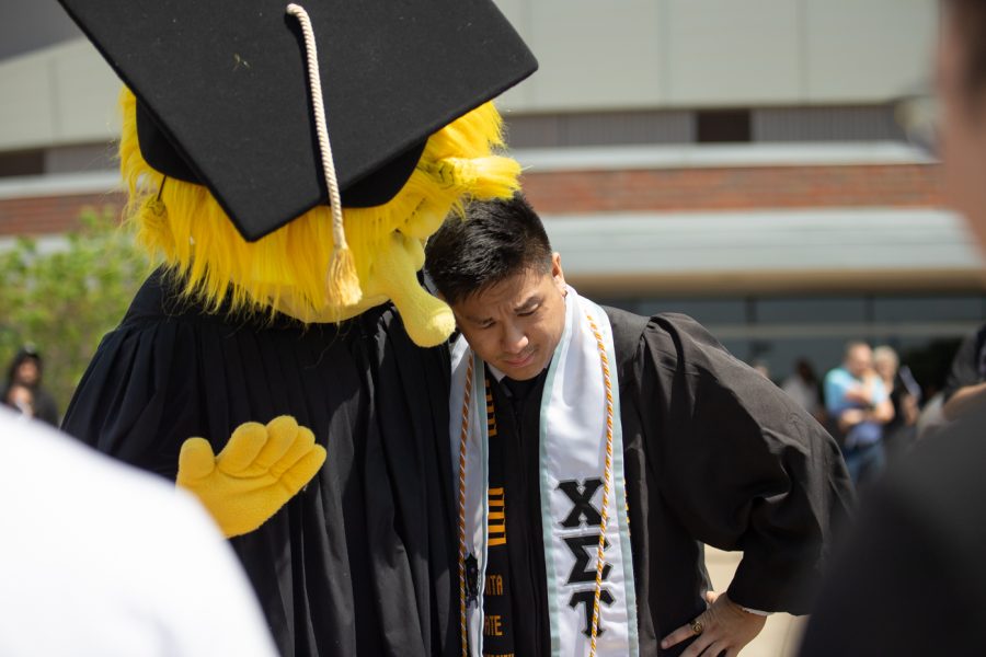 A graduate student leans on WuShock for support after chugging several Bud Lights after the Spring 2022 Commencement Ceremony.