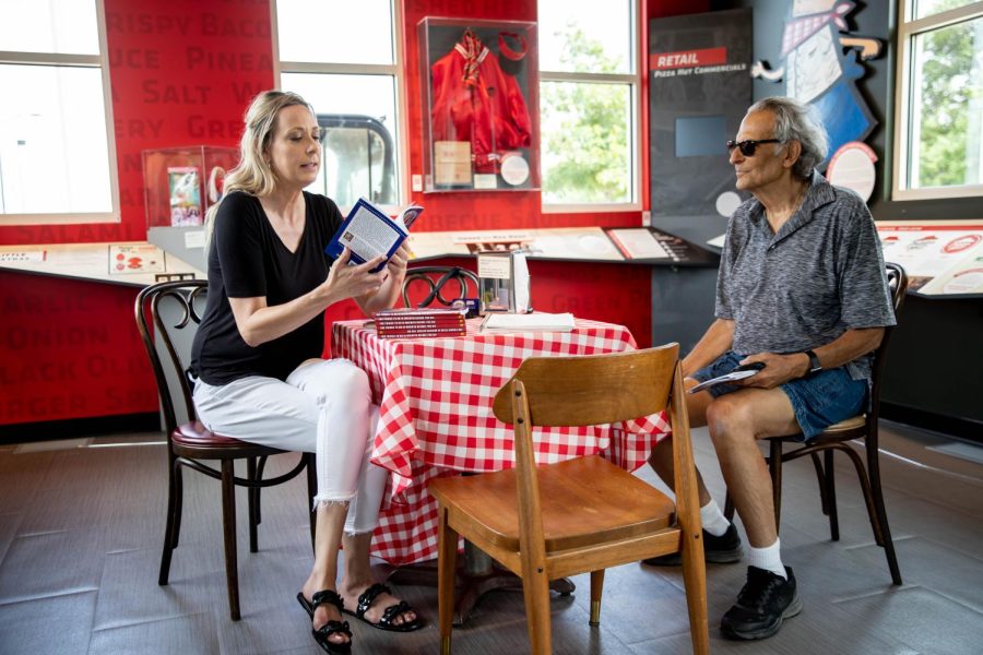 Author Vanessa Whiteside tells a local about her new book 100 Things to Do in Kansas Before You Die. during a signing event at the Pizza Hut Museum on campus.