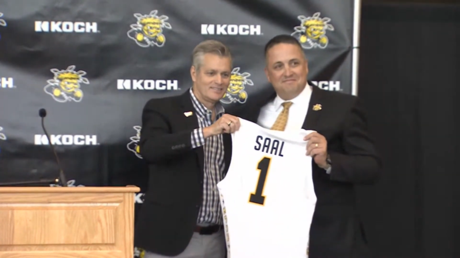 President Rick Muma presents a Shocker jersey to new athletic director Kevin Saal.