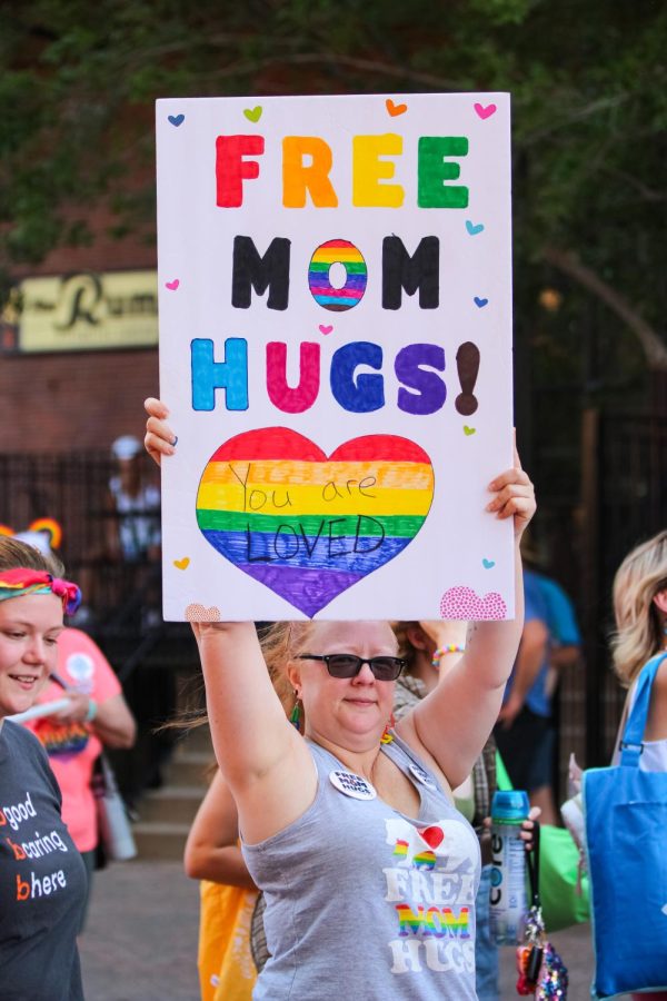 Pride event goer march and show off her Free Mom Hugs! sign at the Unity March held on July 25, 2022. The march began at Old Town Square and ended at Naftzger Park.