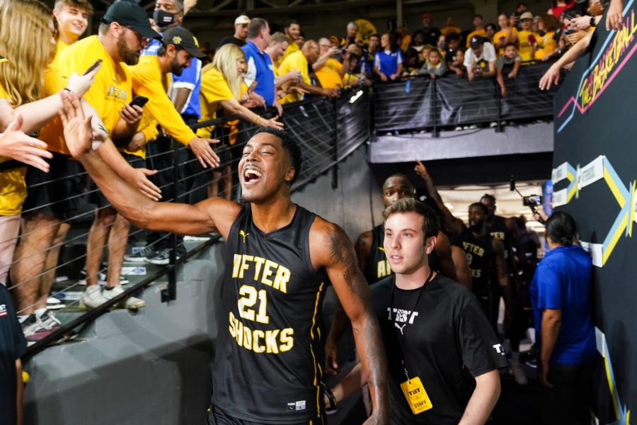 Aftershocks player Darral Willis Jr. celebrates with fans by giving them high fives through the crowd.