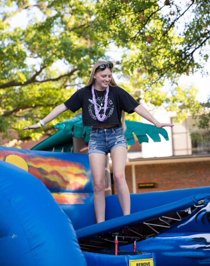 Freshman Vanessa Smith rides mechanical surfboard. The event was hosted by SAC at RSCs east courtyard on Aug 25.