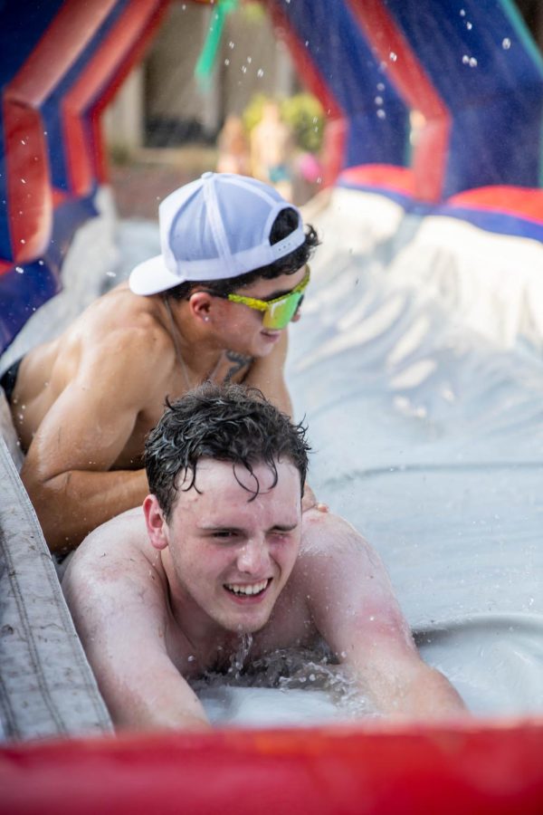 Sophomores Alec and Daniel Ryan slide through a giant water slip-n-slide. The event was hosted by SAC at RSCs east courtyard on Aug 25.