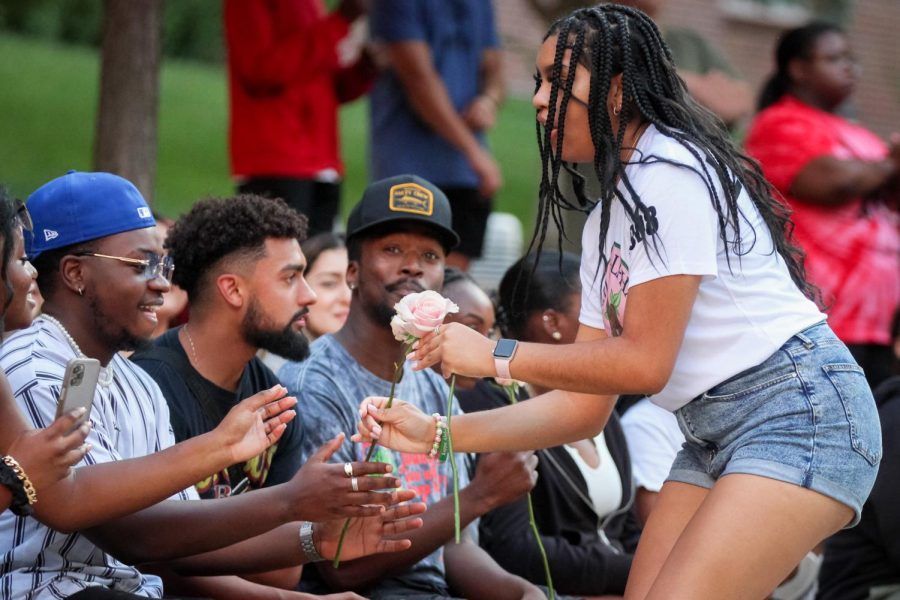 Iris Okere hands out flowers to the audience during Alpha Kappa Alpha Sororitys performance. The first NPHC annual Yard Show was held on Aug. 29.