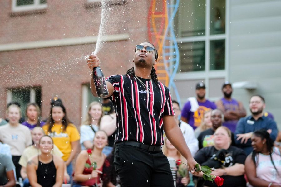 Austin McCartney of Kappa Alpha Psi Fraternity Inc. pops a bottle of champagne at the first annual NPHC Yard Show.