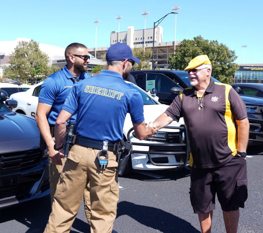 People around wichita talks about cars and interacts with each other at Show N’ Shine car show in parking Lot 1 between Hillside Avenue and the Duerksen Fine Arts Center on Sunday, Sept. 25.