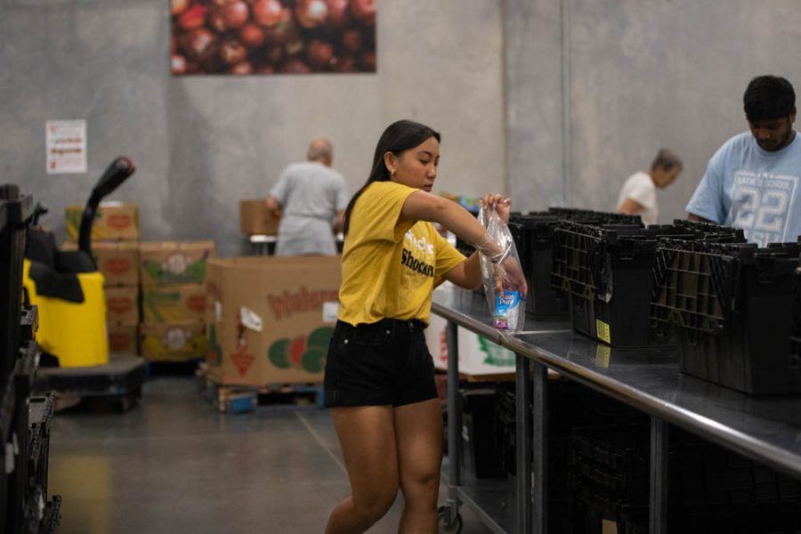 Freshman Amy Nguyen packs up donated food items at the Kansas Food Bank event on Sept. 2.