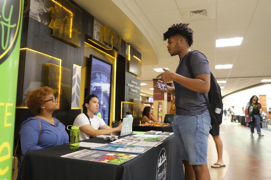 Senior, Thinh Huynh and Grad student, Skyy Freeman answer a students question about the Community Service Board at the Mini Wellness Fair on Sept. 14.