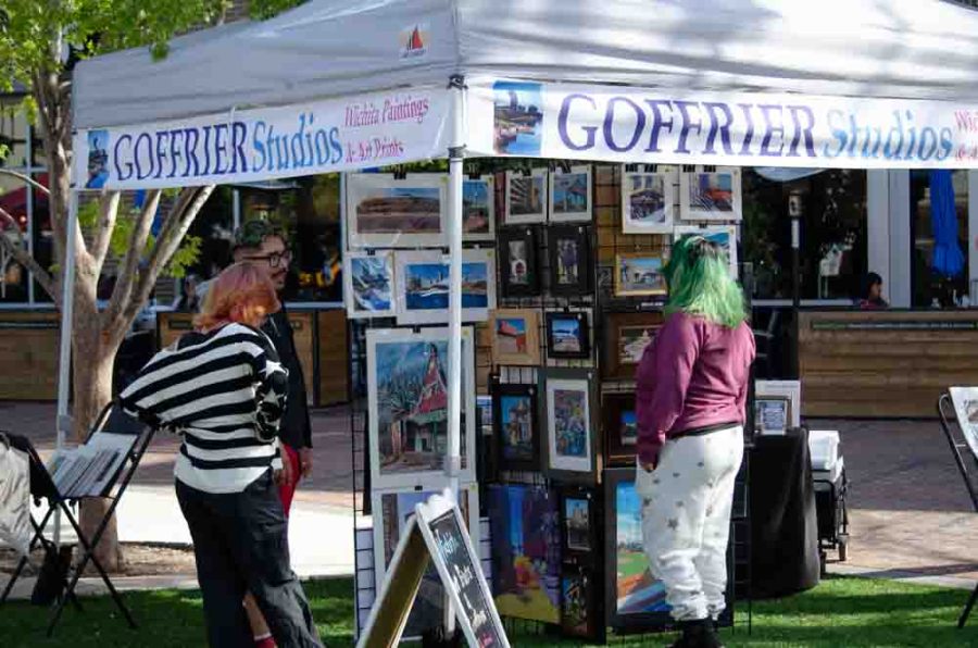 People stop and admire paintings of local settings by Bill Goffrier. Goffrier Studios, owned by Bill Goffrier, was one of the many vendors at this months Shop and Grub.