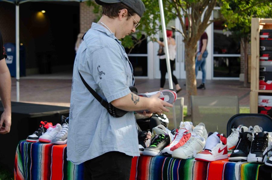 Shopper browses sneaker collection by Stevies Sneaks. Stevies Sneaks makes custom name-brand sneakers.
