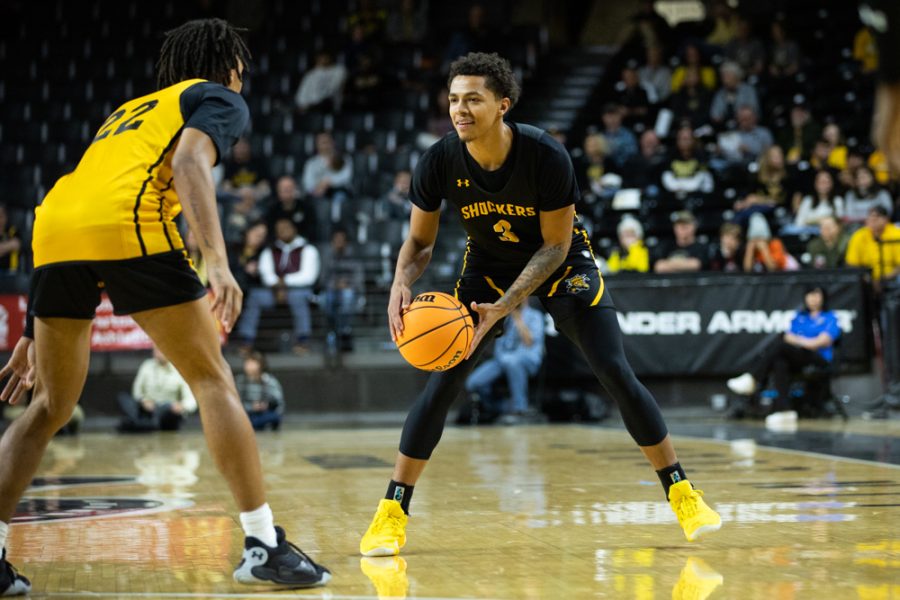 Senior Craig Porter Jr. drives down the court before passing the ball to his teammate on Oct. 27 in Charles Koch Arena.