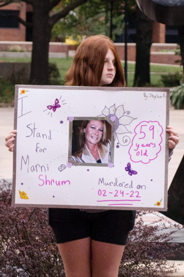 Shylee, a volunteer with Worldbuilders, holds a sign honoring Marni Shrum, who was murdered on Feb. 24, 2022. World Builders and Youth Advisory Council members displayed signs during a moment of silence to honor those who have lost their lives to domestic violence.