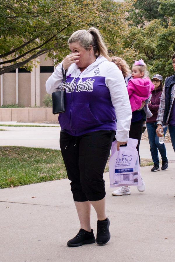 A Purple Mile attendee wipes her eyes as the march begins outside of the Rhatigan Student Center. Many participants were silent or visibly upset as they followed march coordinators and volunteers along the pre-routed march path.