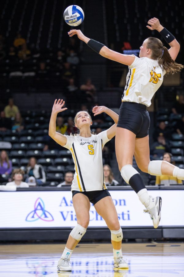 Junior Kaycie Litzau sets the ball for redshirt sophomore Morgan Stout to spike on Oct. 28. The Shockers faced the South Florida Bulls in Koch Arena.